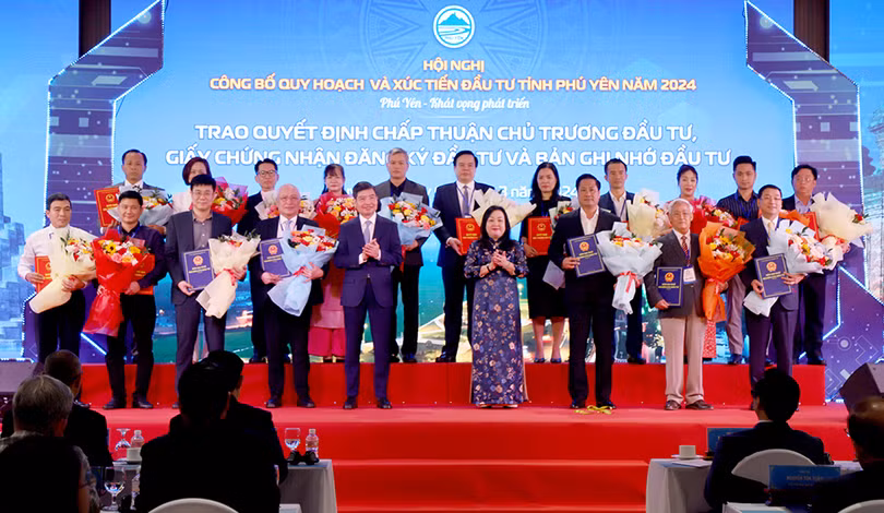 Các đồng chí Cao Thị Hòa An và Tạ Anh Tuấn trao quyết định chủ trương đầu tư, biên bản ghi nhớ hợp tác đầu tư cho các chủ đầu tư. Ảnh: XUÂN TRIỆU