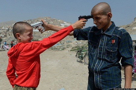 Ngày 8/8: Hai đứa trẻ người Afghanistan chĩa những khẩu súng đồ chơi vào đầu nhau.