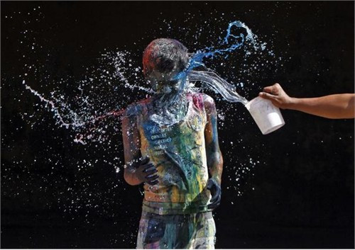 Cậu bé trên người đầy vết màu phản ứng khi một cậu bé khác dội nước vào người trong lễ hội Holi. Holi là lễ hội lớn đầu tiên trong năm của người Hindu. Nó giúp mọi người gần gũi hơn với tôn giáo và văn hóa của họ với các nghi lễ truyền thống như ném bột màu và nước có chứa thuốc dạng bột lên người để ngăn ngừa bệnh. Bên cạnh đó, những đống lửa được đốt ở khắp nơi trên lãnh thổ Ấn Độ như là một dấu hiệu của festival.