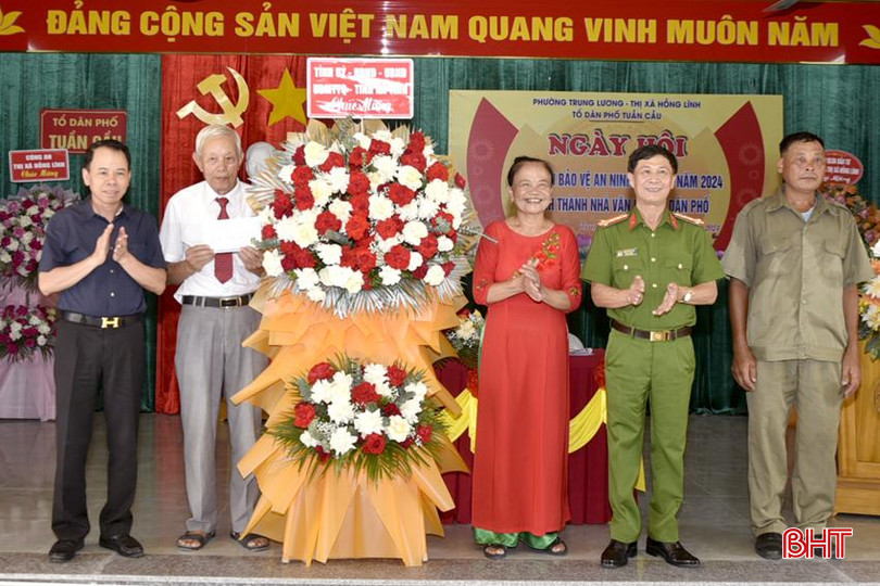 Giám đốc Sở Nội vụ Lê Minh Đạo và Đại tá Đặng Hoài Sơn - Phó Giám đốc Công an tỉnh tặng hoa chúc mừng cán bộ, đảng viên và Nhân dân TDP Tuần Cầu. DT_DSC2295.jpg