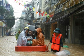 Hà Nội: Nước dâng cao cả mét, người dân dùng thuyền dọn đồ 'chạy lũ'