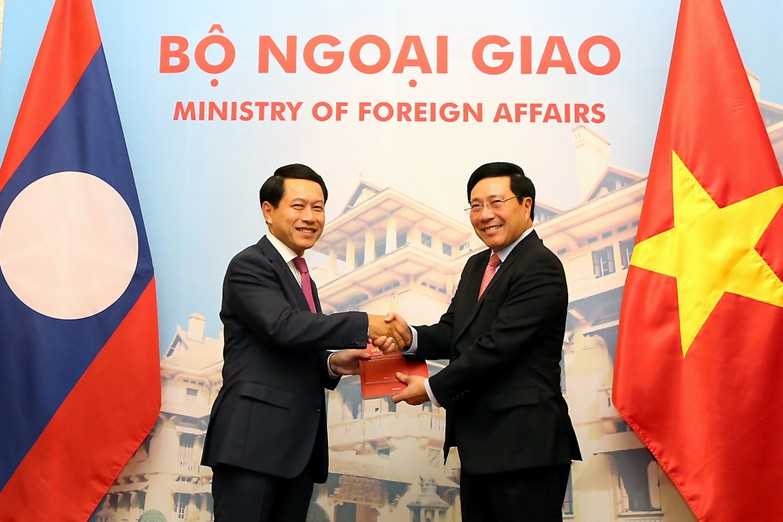 Phó Thủ tướng Phạm Bình Minh và Bộ trưởng Ngoại giao Lào Saleumxay Kommasith trao đổi Nghị định thư về đường biên giới và mốc quốc giới Việt Nam-Lào và Hiệp định về Quy chế quản lý biên giới và cửa khẩu biên giới Việt Nam-Lào. Ảnh: VGP/Hải Minh trao doi hai van kien phap ly quan trong ve bien gioi viet lao