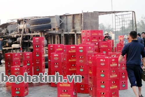 Người dân sở tại giúp tài xế thu dọn những thùng bia đổ