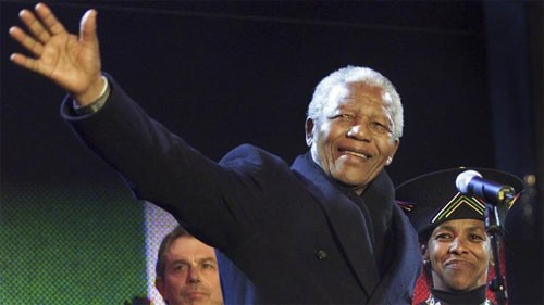 Cựu Tổng thống Nam Phi vẫy tay chào công chúng trong chuyến thăm Anh ngày 29/4/2001 (Ảnh Reuters)