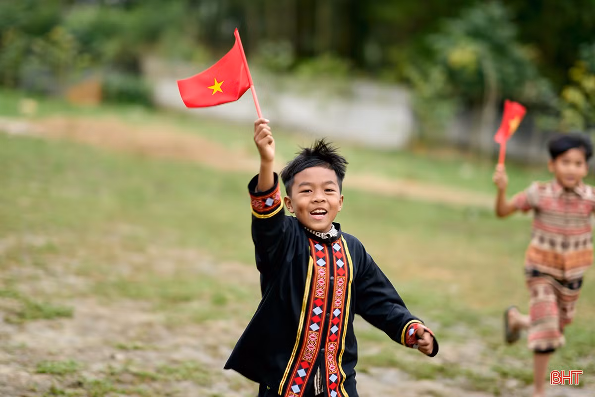 Nụ cười rạng rỡ với lá cờ Tổ quốc trên tay.