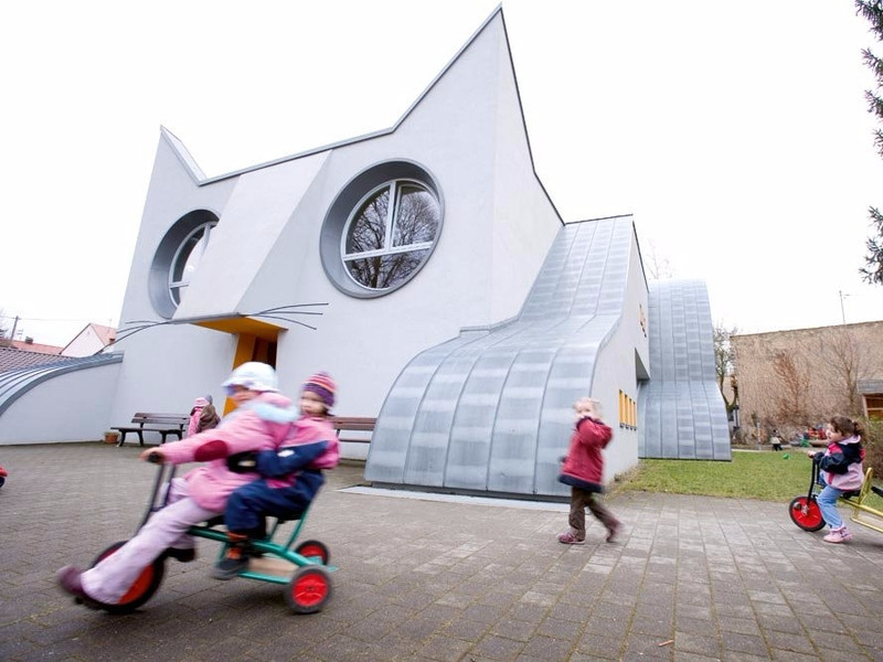 Trường mẫu giáo Wolfartsweier tại thành phố Karlsruhe (Đức) khiến trẻ vô cùng thích thú bởi ngôi trường này được xây theo hình một chú mèo trắng. Miệng của chú mèo chính là lối vào, trong khi lưỡi là một tấm thảm màu đỏ. Ánh sáng tự nhiên ùa vào bên trong thông qua đôi mắt to tròn của chú. nha tre o dong nai lot top nhung truong mau giao dep nhat the gioi