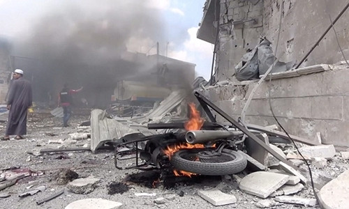 Xe máy cháy sau một cuộc không kích ở Idlib, Syria hồi tháng 7. Ảnh: Reuters. Thế giới nổi bật trong tuần: Mỹ không kích phiến quân Syria