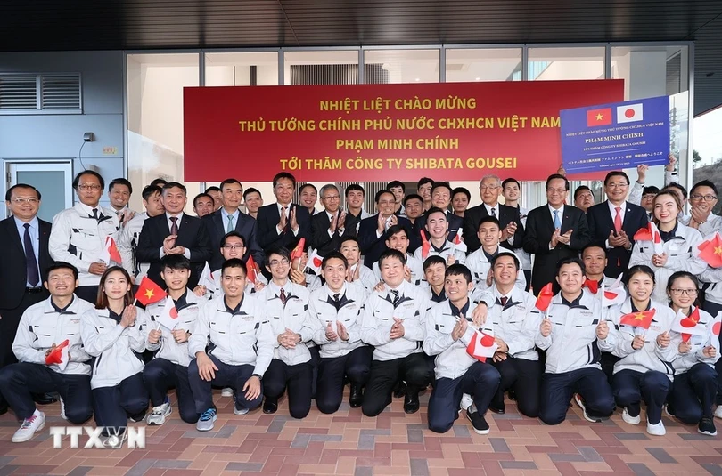 Thủ tướng Phạm Minh Chính với người lao động Việt Nam đang làm việc tại Công ty Cổ phần Shibata Gousei, Nhật Bản. (Ảnh: Dương Giang/TTXVN)