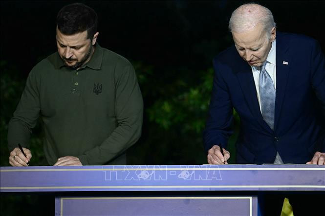 Tổng thống Mỹ Joe Biden (phảii) và Tổng thống Ukraine Volodymyr Zelensky ký thỏa thuận an ninh bên lề Hội nghị thượng đỉnh G7 tại Savelletri, Italy, ngày 13/6/2024. Ảnh: AFP/TTXVN