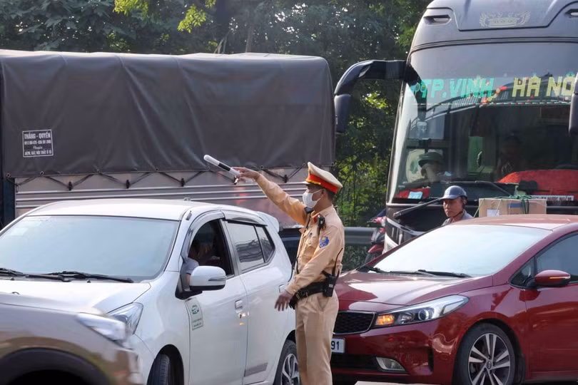 Do lượng phương tiện tăng cao, cán bộ, chiến sĩ Đội CSGT số 14 phải rất vất vả phân luồng, điều tiết giao thông. (Ảnh: Phạm Kiên/TTXVN)