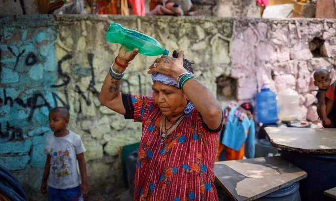 Người phụ nữ dội nước lên đầu để làm mát trong ngày hè oi bức tại New Delhi, Ấn Độ, hôm 21/5. Ảnh: Reuters