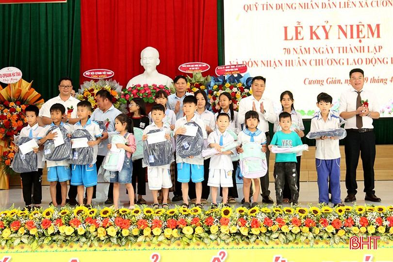 Đại diện Quỹ TDND liên xã Cương Gián và lãnh đạo các xã trao quà cho các em học sinh. bqbht_br_1.jpg