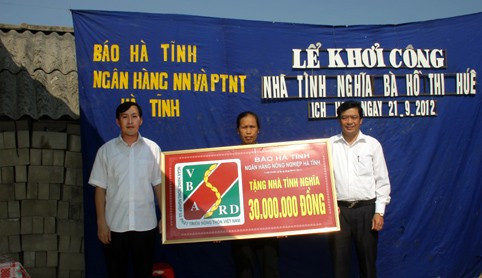 Đại diện lãnh đạo Ngân hàng NN & PTNT tỉnh và Báo Hà Tĩnh hỗ trợ bà Hồ Thị Huế 30 triệu đồng để xây nhà.