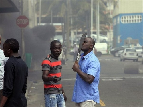 Một người nước ngoài cầm vũ khí trên đường phố Durban trong khi cảnh sát đang đụng độ với nhóm phản đối người nhập cư. (Nguồn: Getty)