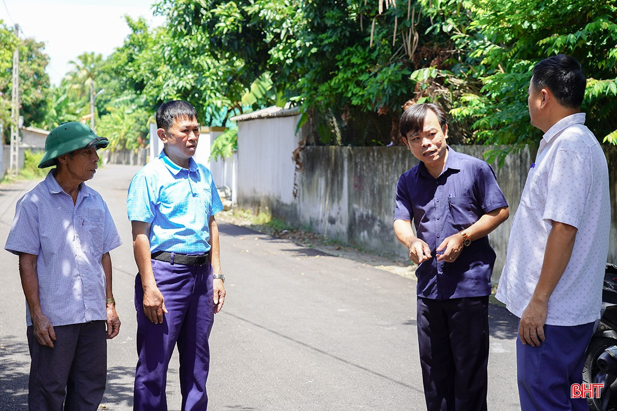 M. Nguyen Xuan Bac (chemise bleue) a discuté avec les responsables du village du processus de construction d'espaces de trottoir après le pavage des routes. bqbht_br_1dsc00185.jpg