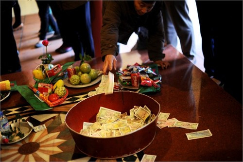 Du khách đi lễ kẹp tiền vào tượng tại Hội Lim (Bắc Ninh) 2014 (ảnh lớn). Tiền lẻ rải khắp nơi ở phủ Tây hồ (Hà Nội). Ảnh: Hải Nguyễn - Giang Huy