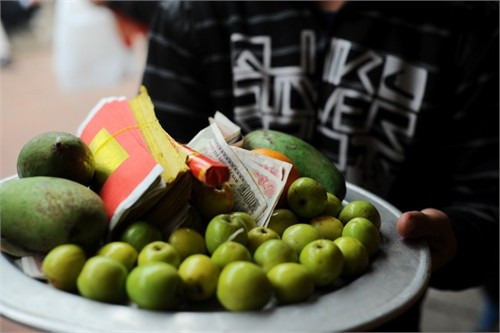 Du khách đi lễ kẹp tiền vào tượng tại Hội Lim (Bắc Ninh) 2014 (ảnh lớn). Tiền lẻ rải khắp nơi ở phủ Tây hồ (Hà Nội). Ảnh: Hải Nguyễn - Giang Huy