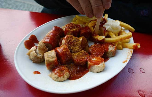 Xúc xích heo được nướng, hoặc hun khói, chiên lên. Sau đó cắt lát rưới nước xốt cà ri, tương ớt lên.