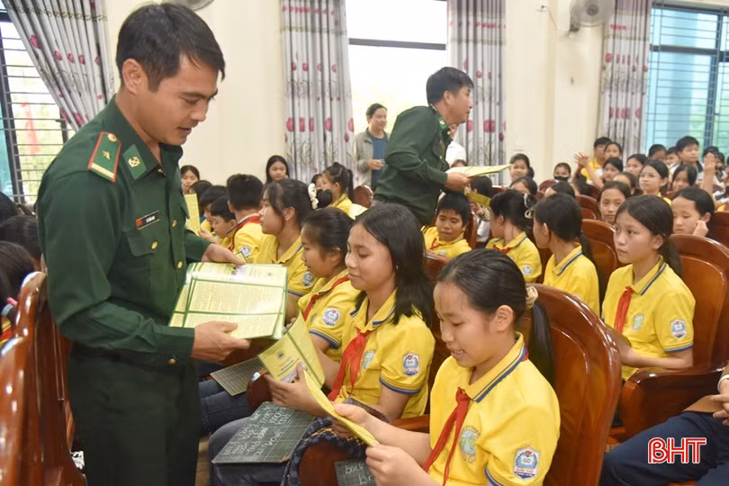 Cán bộ chiến sĩ BĐBP Hương Quang phát tờ rơi tuyên truyền bảo vệ chủ quyền an ninh biên giới cho học sinh Trường TH&amp;THCS Sơn Thọ (huyện Vũ Quang).