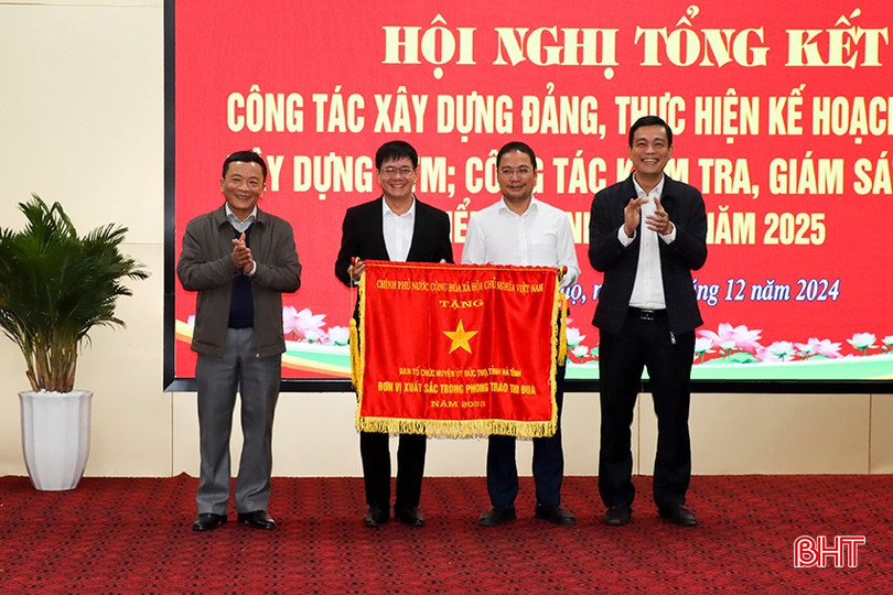 Phó Chủ tịch HĐND tỉnh Trần Văn Kỳ, Bí thư Huyện ủy Nguyễn Thành Đồng trao cờ của Chính phủ cho Ban Tổ chức Huyện ủy Đức Thọ - đơn vị xuất sắc trong phong trào thi đua. bqbht_br_12.jpg