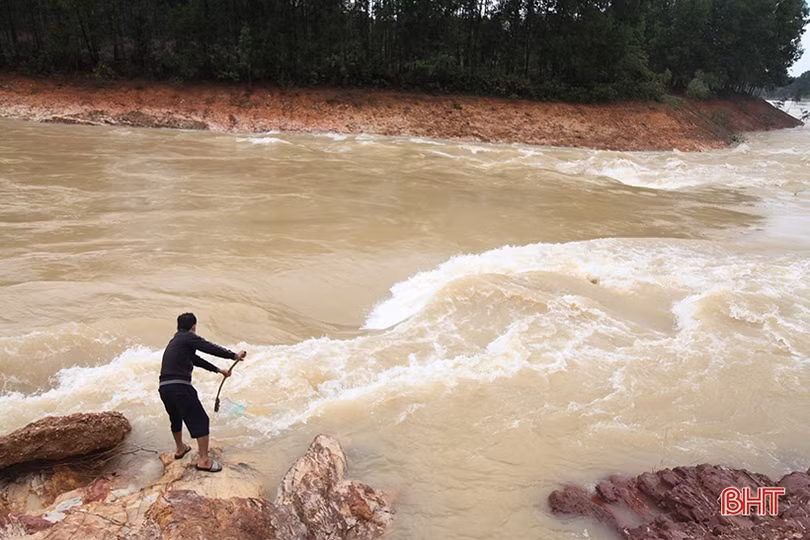 Liều mình bắt cá giữa dòng nước cuồn cuộn khi hồ Kẻ Gỗ xả lũ