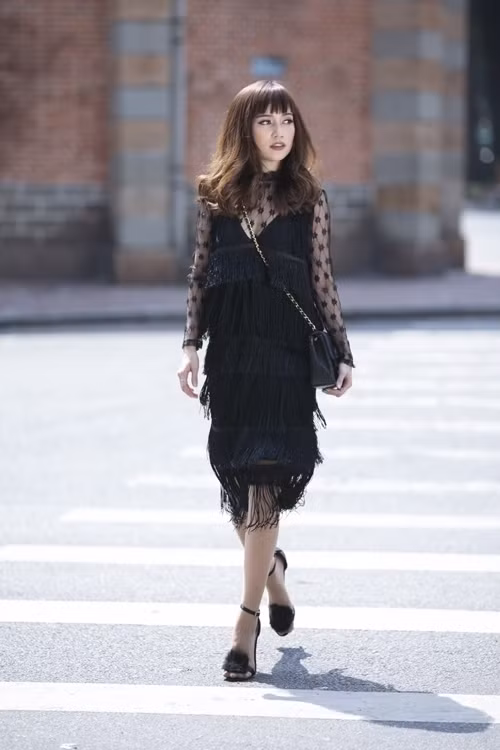 Vạt tua rua mềm được bố trí theo kiểu xếp tầng giúp mẫu váy suông trở nên sống động hơn qua mỗi bước chân của Sĩ Thanh.