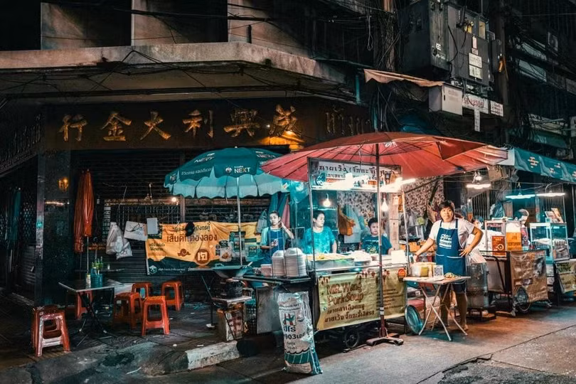 Chủ tiệm tại khu ẩm thực ở Bangkok ngóng khách. Ảnh: Tony Wu/Pexels.