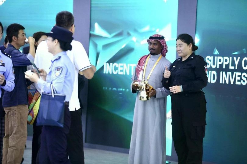 Một nhân viên Trung Quốc chụp ảnh lưu niệm cùng đại diện gian hàng Saudi Arabia. Ảnh: Guanhailou.