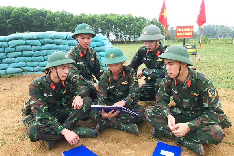 Binh nhất Trần Quốc Bảo (ở giữa) thường xuyên cùng đồng đội trao đổi, nắm chắc những nội dung bài học ngay trên thao trường, bãi tập. anh-3.jpg