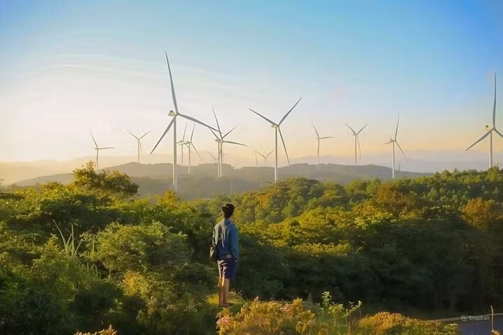 Du khách chụp ảnh lưu niệm cùng những chiếc quạt gió. (Ảnh: Minh Vũ)