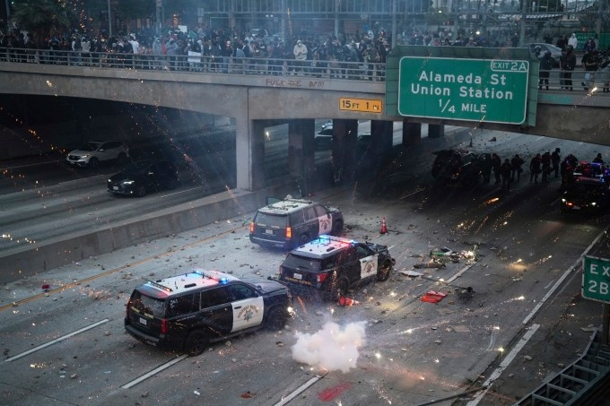 Người biểu tình ném đá, pháo hoa vào xe cảnh sát trên xa lộ 101 gần trung tâm Los Angeles, bang California ngày 8/6. Ảnh: AP Người biểu tình ném đá, pháo hoa vào xe cảnh sát trên xa lộ 101 gần trung tâm Los Angeles, bang California ngày 8/6. Ảnh: AP