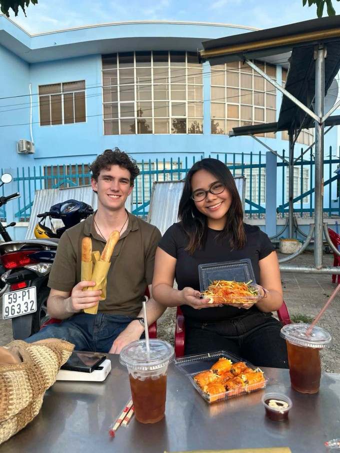 Zane Hanson (ឆ្វេង) អាយុ 21 ឆ្នាំ ជនជាតិ New Zealand រីករាយនឹងអាហារសម្រន់នៅទីក្រុងហូជីមិញ ខែកក្កដា ឆ្នាំ 2025។ រូបថត៖ ផ្តល់ដោយតួអង្គ Zane Hanson (trái), 21 tuổi, người New Zealand thích thú ăn đồ ăn vặt ở TP HCM, tháng 7/2025. Ảnh: Nhân vật cung cấp