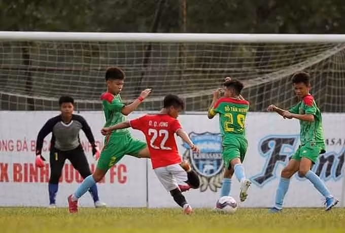 Đậu Quang Hưng (áo đỏ) trong trận đấu với U13 Bình Phước. Nguồn BTC