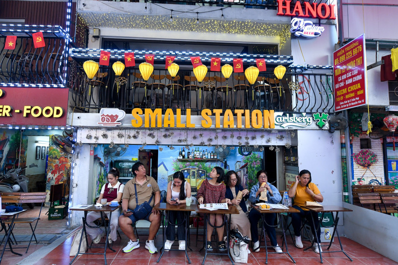 Du khách quốc tế trải nghiệm phố cà phê đường tàu Hà Nội. Ảnh: Trần Hiền.