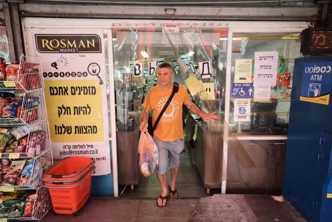 Người đàn ông mua sắm tại một khu chợ ở Haifa, Israel ngày 5/8. Ảnh: AFP