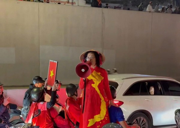 Bà T đứng trên yên xe máy hô hào đua xe tại hầm Kim Liên rạng sáng 17/1 (ảnh cắt từ clip).