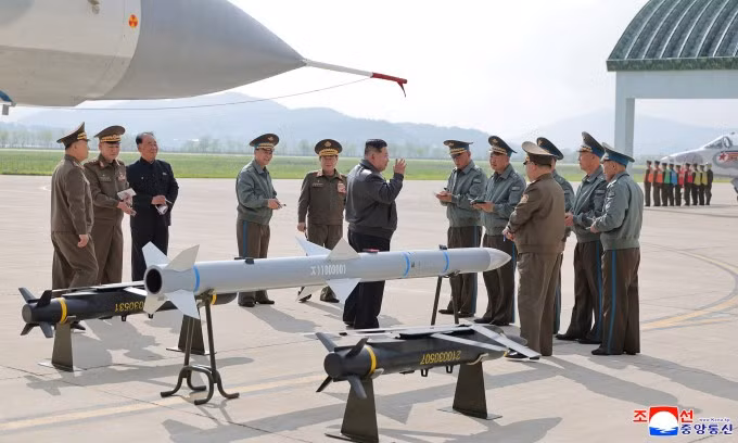 Ông Kim Jong-un bên cạnh mẫu tên lửa, bom mới trong ảnh công bố hôm nay. Ảnh: KCNA