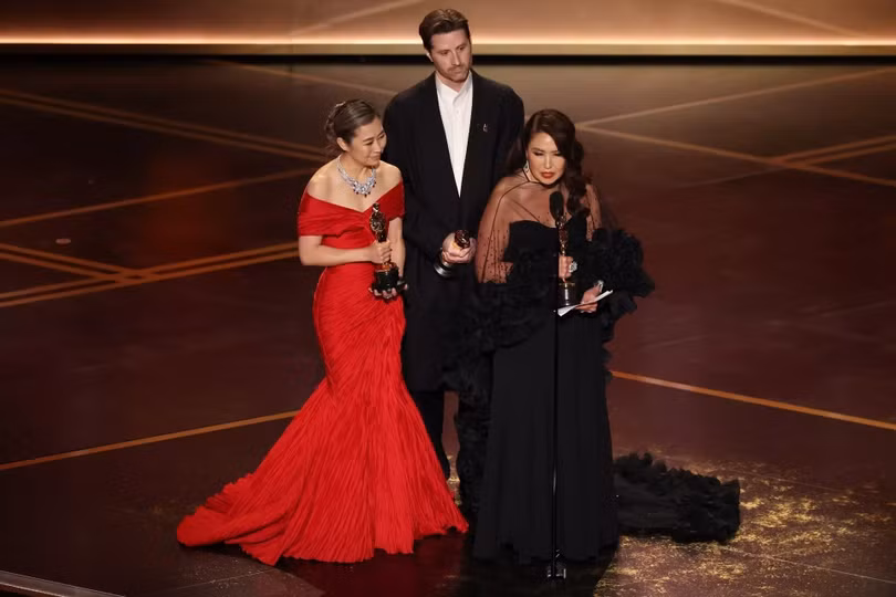 Ê-kíp K-pop Demon Hunters trên sân khấu nhận giải. Ảnh: Los Angeles Times.