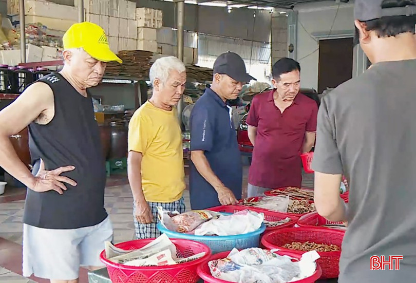 Ông Trần Xuân Hùng (áo đỏ) cùng đoàn du khách chọn các loại đặc sản của Hà Tĩnh mua về biếu người thân. bqbht_br_untitled-12.jpg