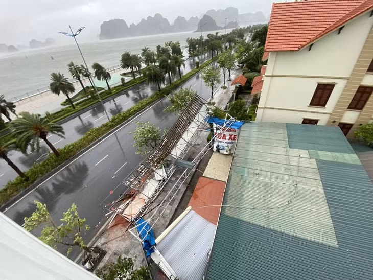 Tại thành phố Hạ Long lúc 12h gió rít từng cơn rất mạnh kèm theo mưa. Tại khu vực đường bao biển Hạ Long biển quảng cáo cùng cửa cuốn bị gió bão cuốn đổ ra đường - Ảnh: C. TUỆ