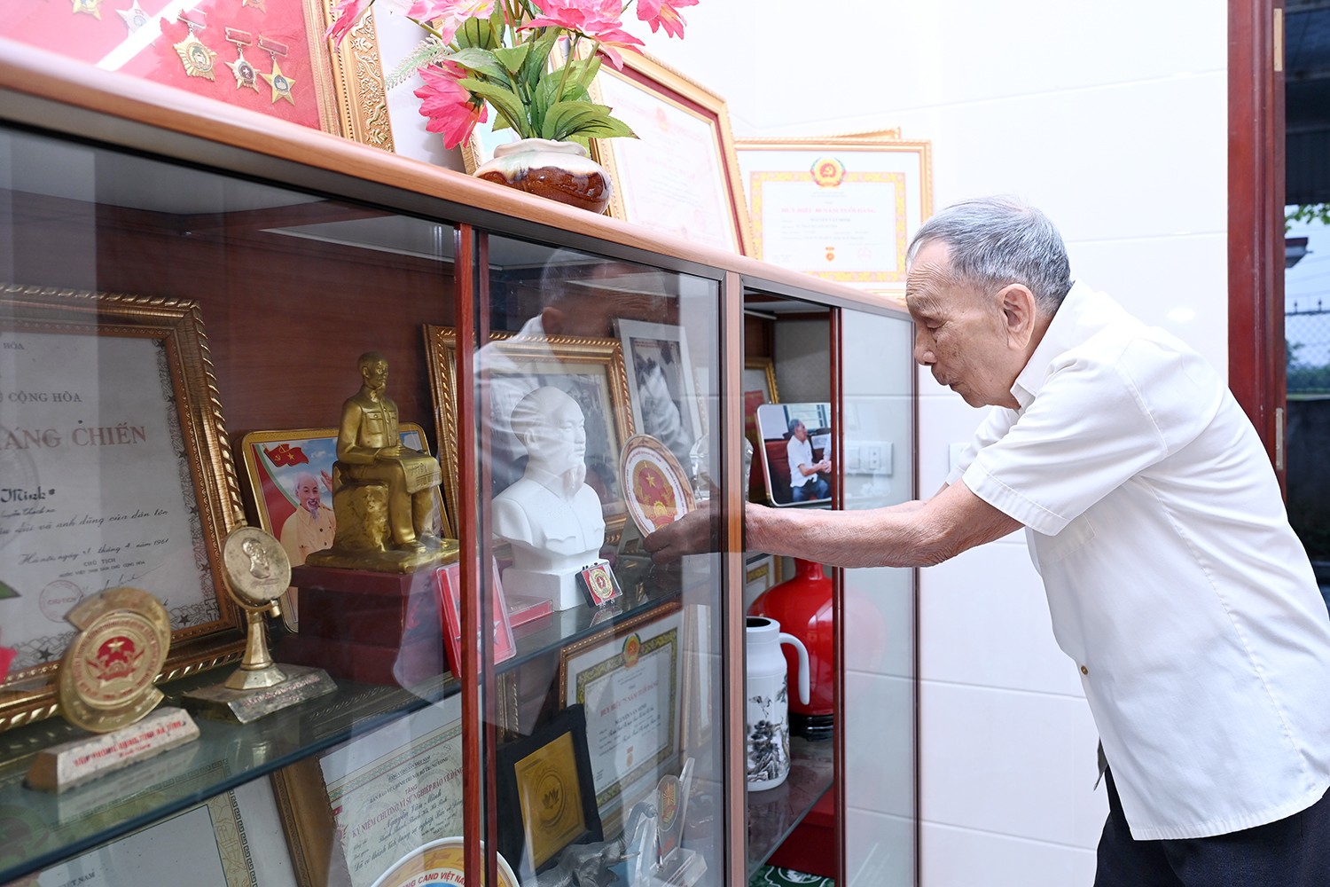 Trong căn nhà nhỏ, bức tượng Bác Hồ cùng những tấm giấy khen, bằng khen và các vật lưu niệm được cụ Minh trân trọng giữ gìn. dsc-d5600.jpg