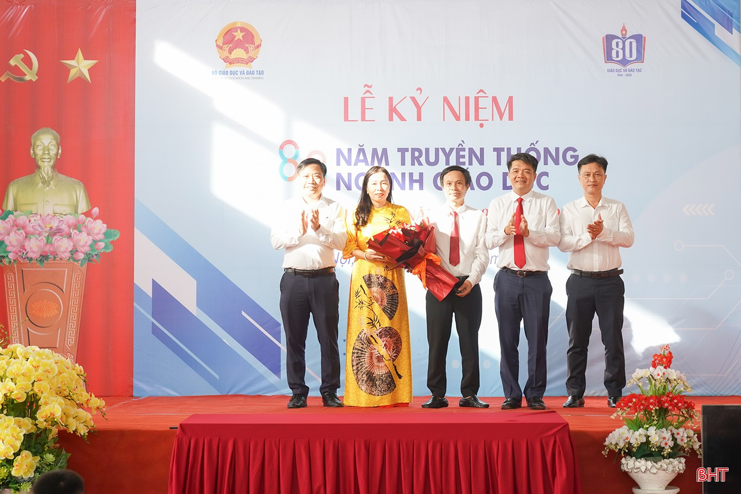 Chủ tịch Ủy ban MTTQ tỉnh Trần Nhật Tân tặng hoa và chúc mừng Ban Giám hiệu Trường THCS Lê Bình.