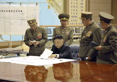 Bức ảnh cho thấy nhà lãnh đạo Kim Jong-un cùng các tướng lĩnh trong một căn phòng có vẻ như là phòng tác chiến quân sự. Phía sau bên trái là tấm bản đồ với dòng chữ "Kế hoạch Tấn công Lục địa Mỹ của Các lực lượng Chiến lược". Ảnh: KCNA/AFP