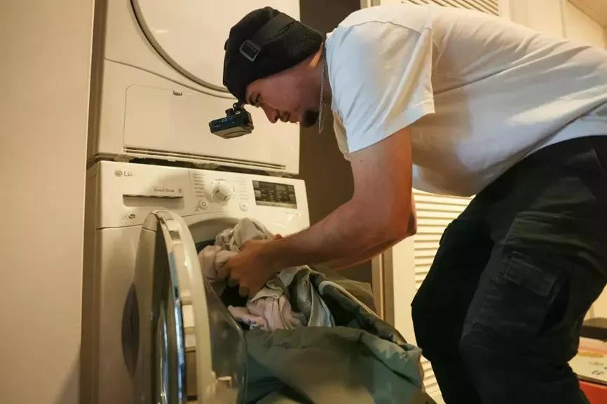 Alcija tự quay video cảnh mình cho quần áo vào máy giặt. Ảnh: TencentNews.