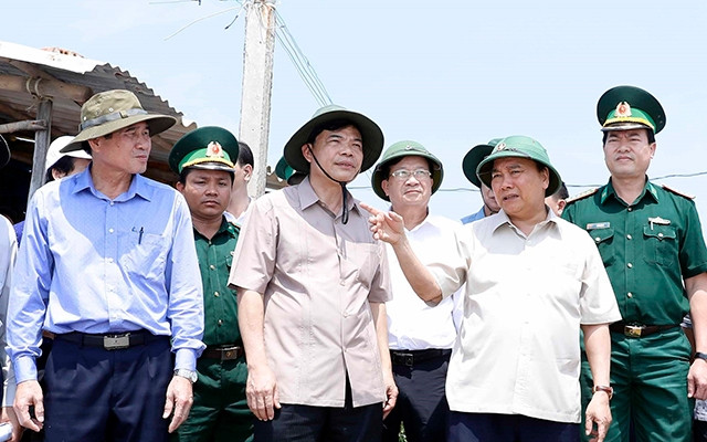 Thủ tướng Nguyễn Xuân Phúc thị sát điểm sạt lở tại xã Tân Thành, huyện Gò Công Đông, tỉnh Tiền Giang tháng 9/2019. Ảnh: TTXVN Chắt chiu tăng trưởng trên những nẻo đường nắng mưa