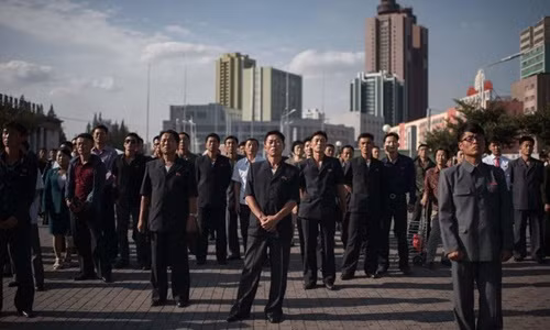 Người dân tại thủ đô Bình Nhưỡng, Triều Tiên, hôm 22/9 đứng xem bản tin đưa về tuyên bố của nhà lãnh đạo Kim Jong-un đáp trả Tổng thống Mỹ. Ảnh: AFP. he qua kho luong tu cuoc khau chien trump kim jong un