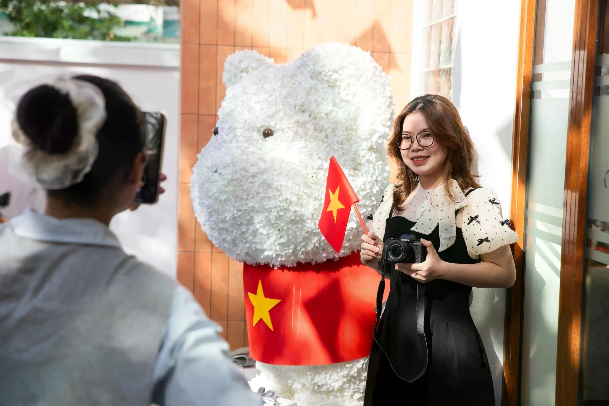 Chia sẻ với Tri Thức - Znews, Nguyễn Thị Hoài Ninh (35 tuổi), chủ quán ChiNi Tee &amp; Coffee, cho biết từ cuối tháng 3, quán bắt tay vào trang trí theo chủ đề 30/4 với sắc đỏ chủ đạo, sử dụng hình ảnh cờ Tổ quốc để làm điểm nhấn. Toàn bộ vật dụng trang trí như cờ, áo gấu bông hình cờ đỏ sao vàng, báo in, cờ cầm tay... đều được chuẩn bị thủ công, thiết kế riêng và được khách hàng yêu thích. Chủ quán tiết lộ chi phí cho những đồ trang trí này đều rất rẻ, song mang lại hiệu quả cao về mặt hiệu ứng, giúp quán được biết đến nhiều hơn.