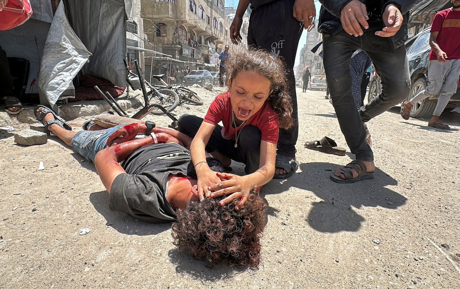 Bé gái bật khóc chứng kiến người thân bị thương trong cuộc không kích do Israel tiến hành tại Dải Gaza ngày 5/6.