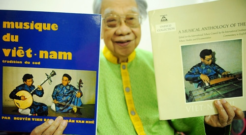 Giáo sư bên các đĩa than ông từng thực hiện, trong đó có đĩa than ông hòa đàn cùng nhạc sư Nguyễn Vĩnh Bảo (trái). Ảnh: Nguyễn Á