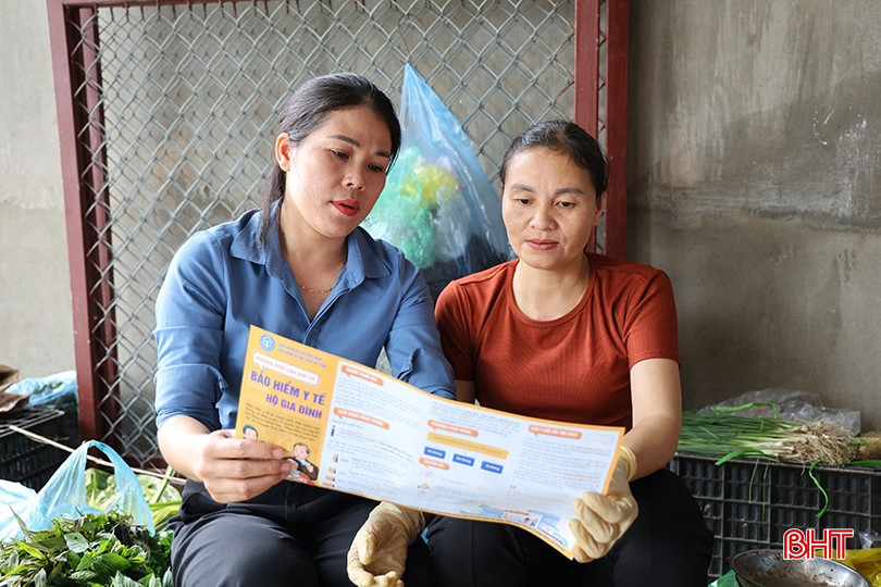 Chị Lê Thị Tâm ra tận chợ để giải đáp những thắc mắc của chị Trần Thị Huyền về những thay đổi mức đóng BHYT. 14-9985.jpg